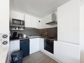 Préparez-vous de délicieux repas dans cette cuisine moderne toute équipée, avec son élégante plaque de cuisson et ses rangements astucieux. Profitez du confort et de la fonctionnalité dans une ambiance épurée.