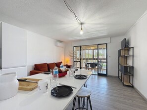 Dans cet espace décloisonné baigné de lumière, dégustez un repas convivial au bar avant de vous détendre sur le canapé avec vue sur l'extérieur. La climatisation assure un confort optimal en toute saison.