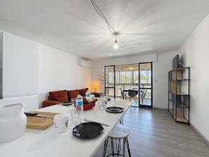 Dans cet espace décloisonné baigné de lumière, dégustez un repas convivial au bar avant de vous détendre sur le canapé avec vue sur l'extérieur. La climatisation assure un confort optimal en toute saison.