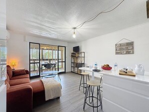 Imaginez-vous partager un repas avec vue sur la véranda. L'espace lumineux et aéré offre une transition harmonieuse entre l'intérieur et l'extérieur, parfait pour la détente.