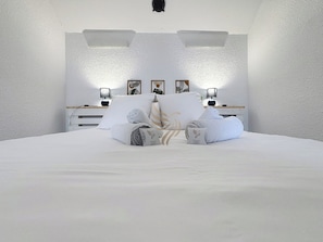Profitez d'une chambre moderne et épurée. Imaginez-vous détendu sous ces lumières douces, entouré de murs apaisants, prêt à vous reposer après une journée bien remplie.