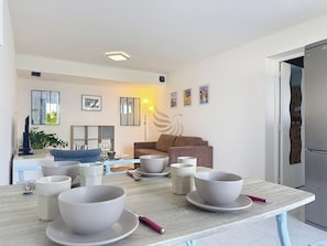 La table à manger peut devenir le centre de grandes soirées conviviales grâce à son agencement pratique et l'ouverture sur le salon permet des interactions fluides entre les invités.