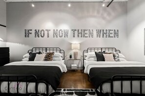 Spacious bedroom with two king-size beds and bold modern decor, perfect for families or groups
