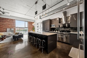 Modern kitchen with upscale appliances, large island, and open layout flowing into the living space