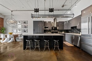 Large modern kitchen with upscale stainless steel appliances  great for dining in.