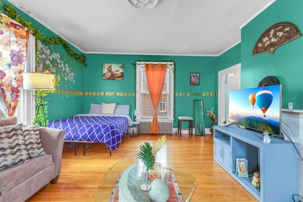 Bright living room with green walls, plush seating, and hardwood floors.