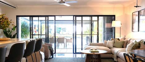 Sunshine Villa’s downstairs blends indoor & outdoor living with an open-plan kitchen, dining and living area. A cozy study nook adds functionality, while large glass doors bring in natural light & connect the spacious interior to the outdoor retreat