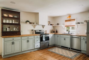 The spacious kitchen blends charm and functionality, offering plenty of room to cook, gather, and enjoy time together in a warm, inviting setting.