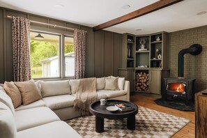 Gather in the living room with the fire in view, surrounded by warm light, comfortable seating, and the perfect atmosphere for connection and relaxation.