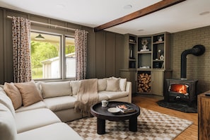 Gather in the living room with the fire in view, surrounded by warm light, comfortable seating, and the perfect atmosphere for connection and relaxation.
