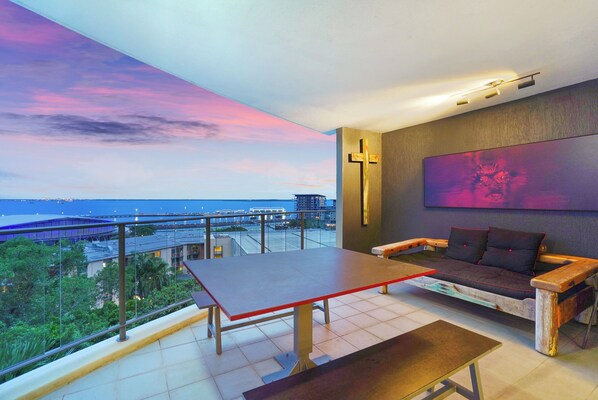 Balcony relaxation with day bed, outdoor dining and harbour views.