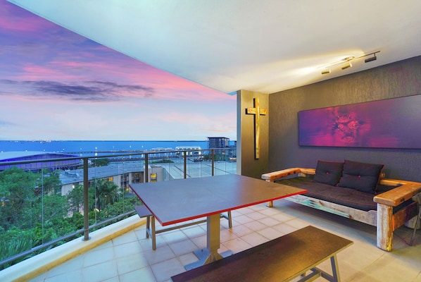 Balcony relaxation with day bed, outdoor dining and harbour views.