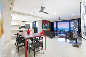 Dining living and kitchen areas, all open onto balcony with access via two separate glass sliding doors.