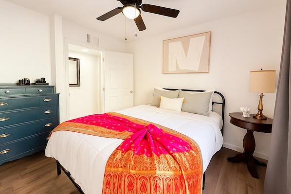 Bedroom with queen bed, blackout curtains, ceiling fan, and full closet