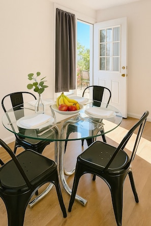 Bright dining area with seating for four, natural light, and patio access