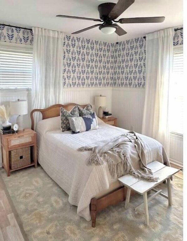 Cozy beach cottage bedroom with full vintage bedframe, closet, coastal wallpaper