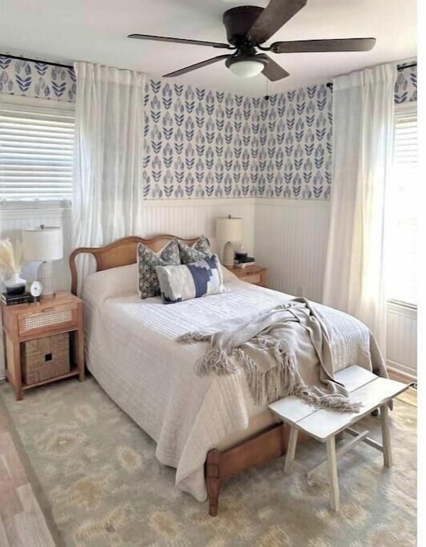 Cozy beach cottage bedroom with full vintage bedframe, closet, coastal wallpaper