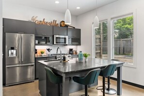 Updated, fully-equipped kitchen with high-end appliances and seating for four at the counter.