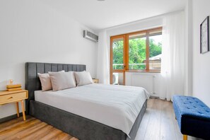 Unwind in a soft queen-size bed with green views and natural light for a restful night’s sleep