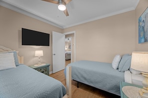 Cozy bedroom with two twin beds & smart TV for a comfy, fun stay.