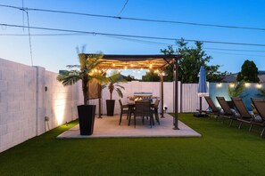 Cozy outdoor area to share a meal, fire up the BBQ, and relax in your private backyard oasis. Beautiful lighting all around creates the perfect ambiance for unforgettable evenings under the stars.
