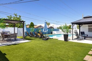 Private backyard oasis with *heated pool*, cozy fire pit, lounge chaises, and outdoor dining. The perfect space to relax, soak up the sun, and enjoy unforgettable evenings under the stars.