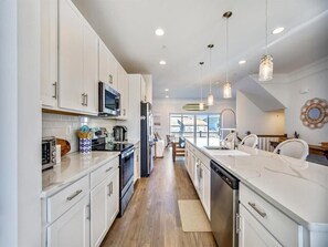 Experience culinary bliss in a modern kitchen featuring sleek countertops, stainless steel appliances, and an open layout perfect for family gatherings.