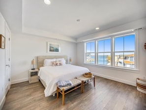 Revel in stunning waterfront views from this charming bedroom, which provides an ideal setting for unwinding after a beach day.
