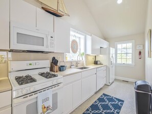 Bright and airy kitchen featuring a gas stove, microwave, and plenty of storage for extended stays.