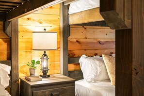 Large bunk room with queen-over-queen beds, TV, and ensuite bath.