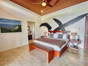 Suite #1 with king-size bed, ocean views, patio access, A/C, ceiling fan and en-suite bathroom. 