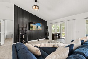 This spacious living room features comfy sofas, a smart TV, and lots of natural light, perfect for movie nights or lazy afternoons.