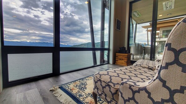 Floor to ceiling windows in living rm w a seating area to ponder the lake