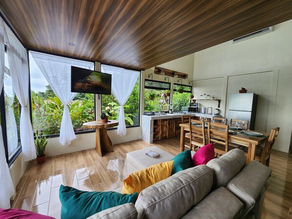 Living area and kitchen with large windows and lovely city and rainforest views