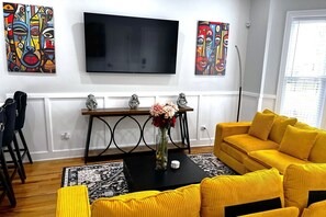 Living Room with L-shaped sectional couch and 4K 65" Roku TV