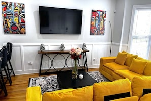 Living Room with L-shaped sectional couch and 4K 65" Roku TV