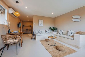 Spacious and airy living room featuring built-in seating, textured rugs, and a clean minimalist design.

