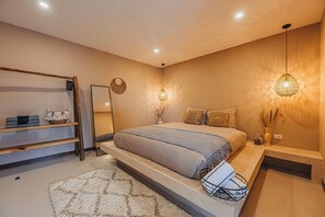 Warm and welcoming bedroom with a king-sized bed, open shelving, and soft ambient lighting.

