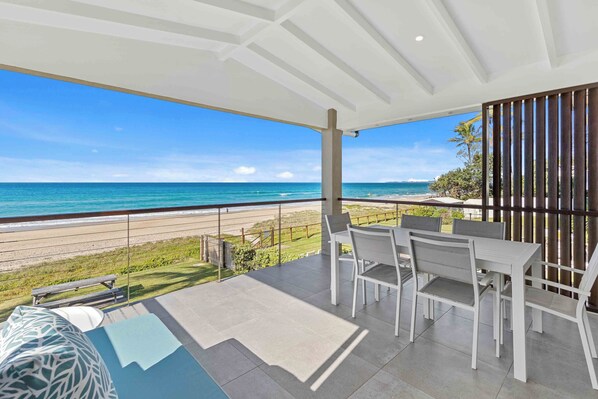 Private balcony with a table and chairs, ideal for enjoying morning coffee or evening drinks while taking in the sea breeze.