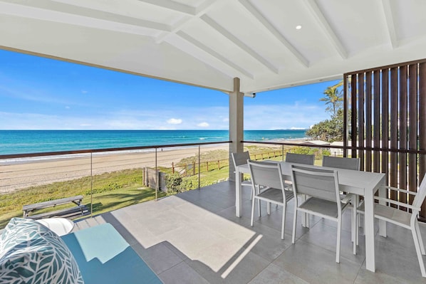 Private balcony with a table and chairs, ideal for enjoying morning coffee or evening drinks while taking in the sea breeze.