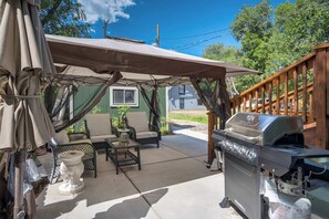 Enjoy outdoor meals and relaxing afternoons in the shaded shared patio area with a BBQ grill and comfortable seating.

