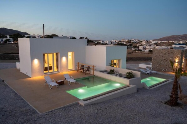 Tranquil private pool terrace beautifully lit for evening relaxation.