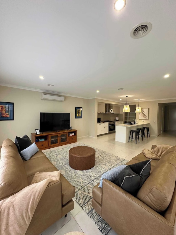 Main living area with flat screen TV, beautiful furnishings and direct access to the kitchen/dining and outdoor area.