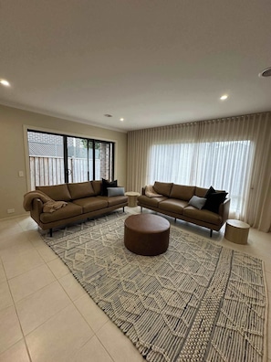 Main living area with flat screen TV, beautiful furnishings and direct access to the kitchen/dining and outdoor area.
