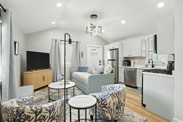 Bright and cozy living area with a smart TV, two patterned accent chairs, and a stylish daybed that converts into two twin beds—perfect for families visiting students at Valpo University. Enjoy a fully stocked kitchen with stainless steel appliances.