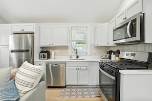 Fully equipped kitchen featuring stainless steel appliances, a gas range, microwave, dishwasher, and modern coffee & tea station—perfect for home-cooked meals or quick bites while visiting Valpo. Bright, clean, and ready for your stay!