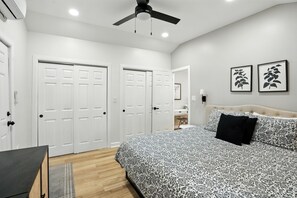 Stretch out in comfort in this serene main bedroom, complete with a luxurious king-size bed, dual closets, soft lighting, and a ceiling fan for added comfort. A calming space with modern touches—perfect for unwinding after a day of exploring Valpo or the I
