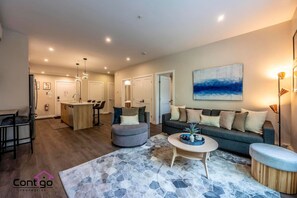 Spacious open-concept living area with smart TV (log into your own apps), cable, and a small sofa bed for extra guests.