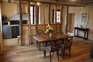 Cuisine ouverte sur le séjour, avec la porte d'entrée au fond à droite.