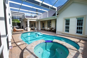 Screened patio with pool, spa, hammock & seating—perfect for day or night